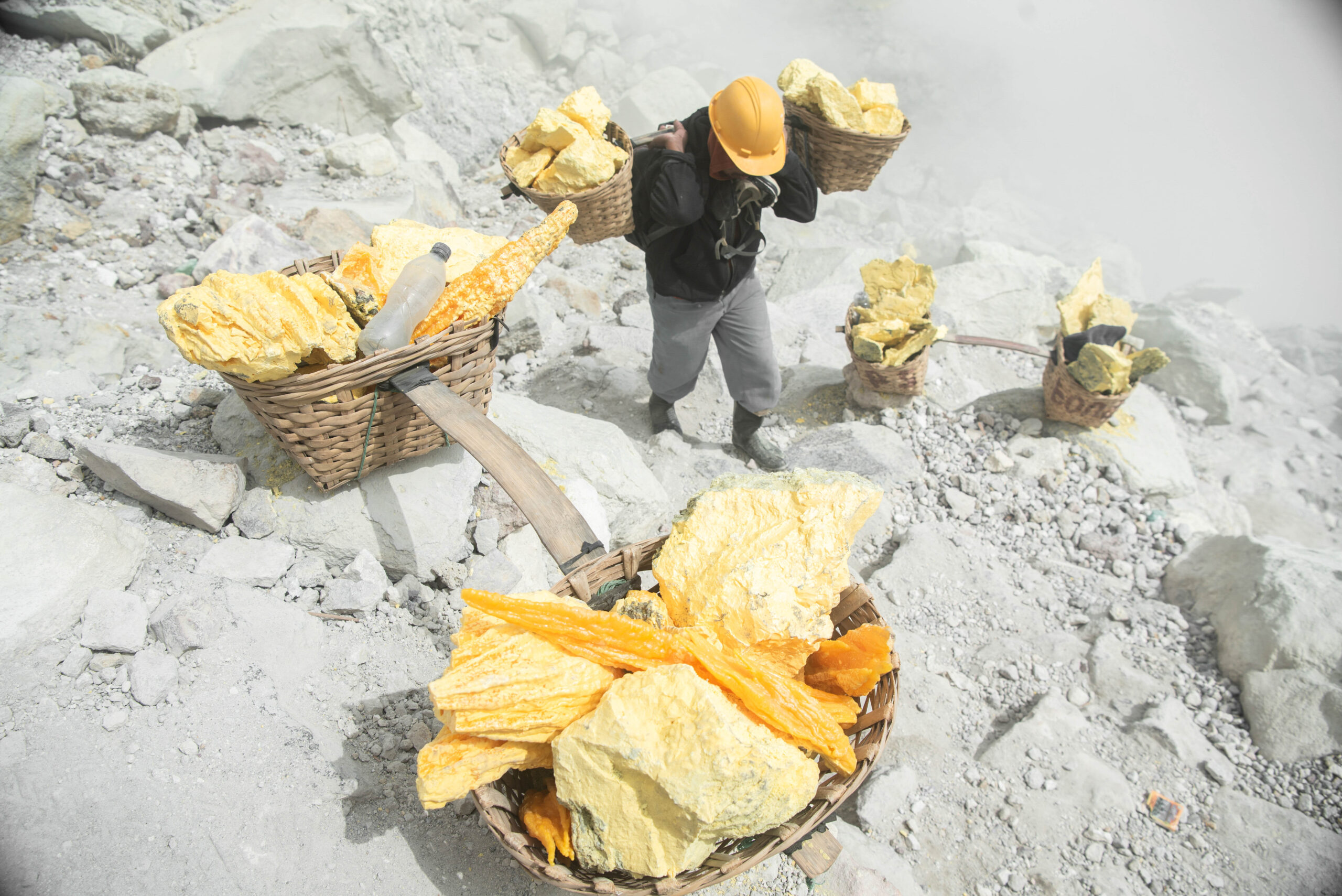 A miner is going back to the top of the volcano with two baskets loaded with sulfur at Kawah Ijen, Indonesia.

On average, the weight of two full baskets is equal to 70-80 kg (155-177 lbs).
The miners must climb to the top with full baskets resting on
their shoulders.
